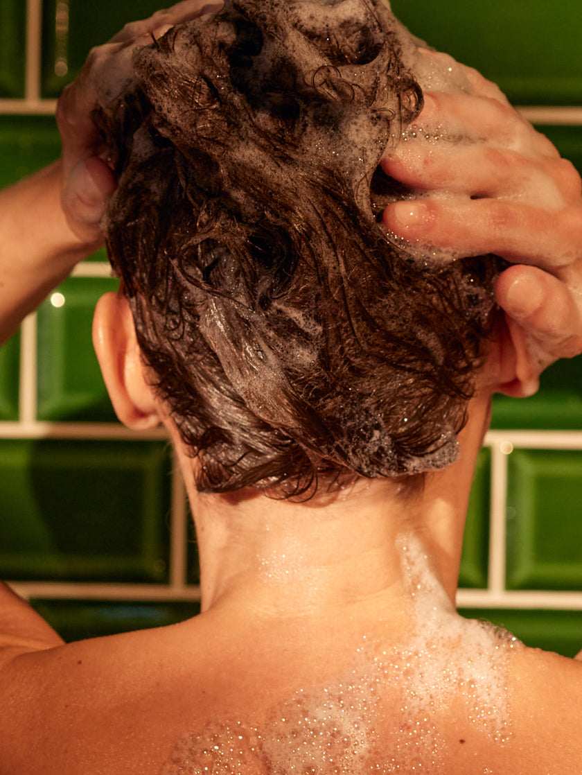 Image of shampoo foam, model in the shower with khadi product