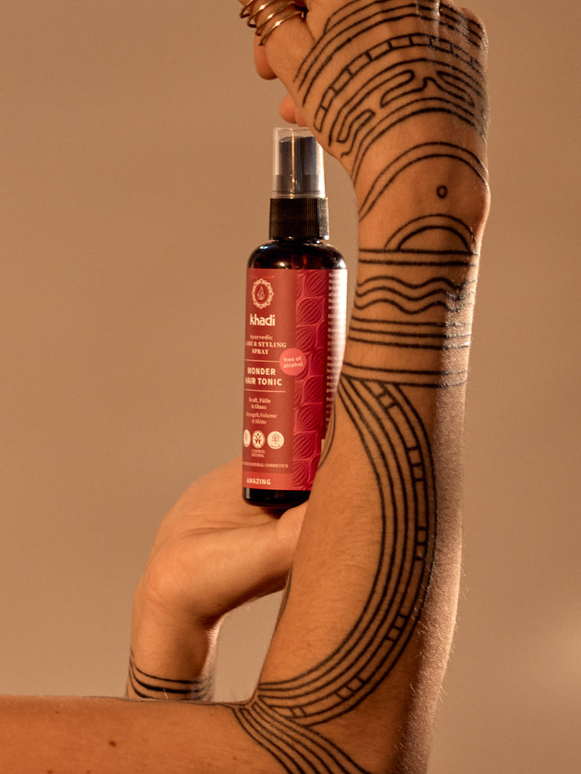 Image of Wonder Hair Tonic, model holding the product in their hand